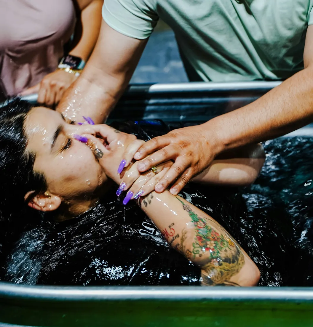 Woman being baptized in the baptismal pool