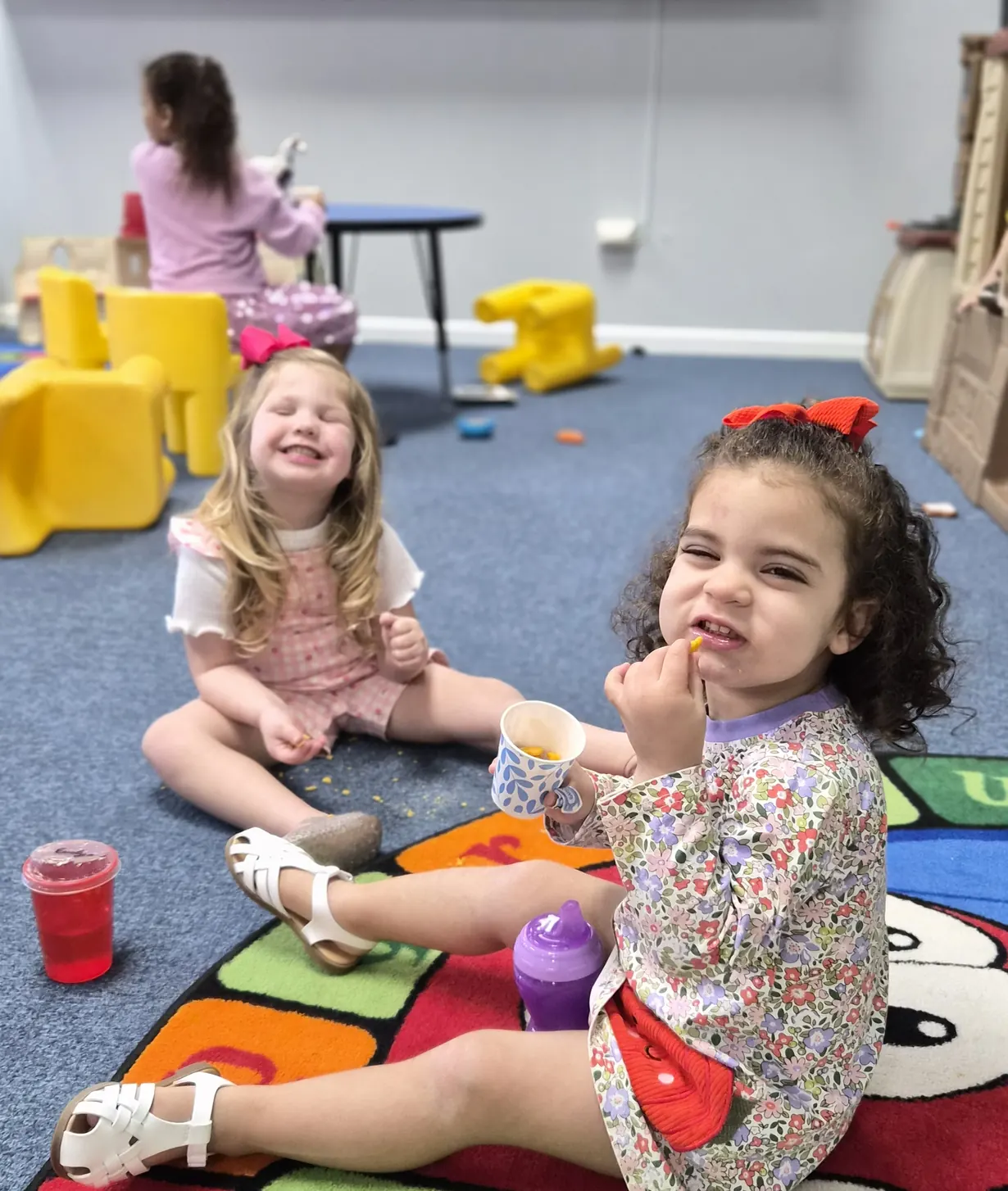 Little girl smiling on a colorful play mat