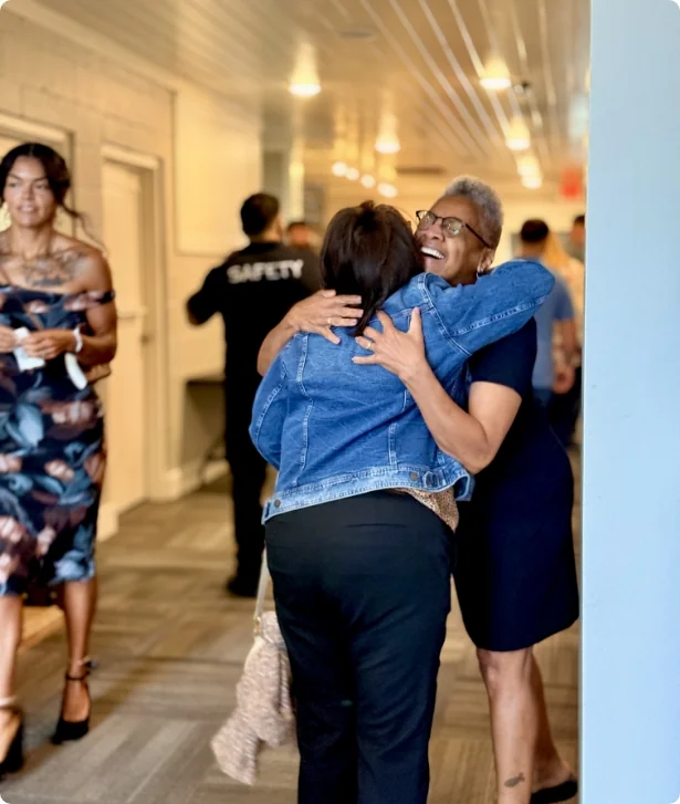 Two women hugging in the church hallway